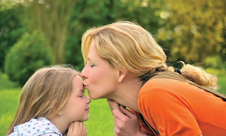 a woman kissing the forehead of a child